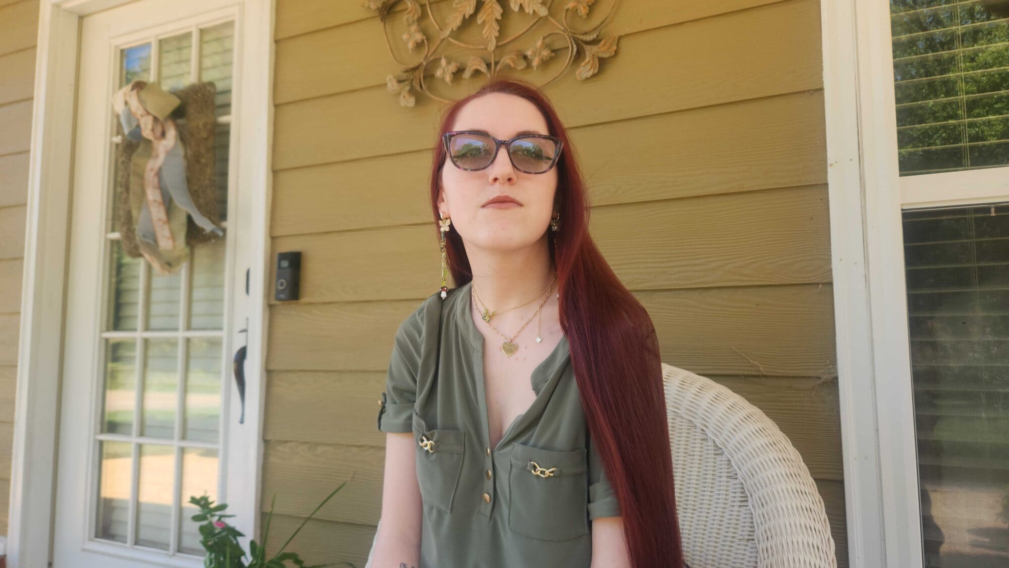 Zoey Tether sits outside a house