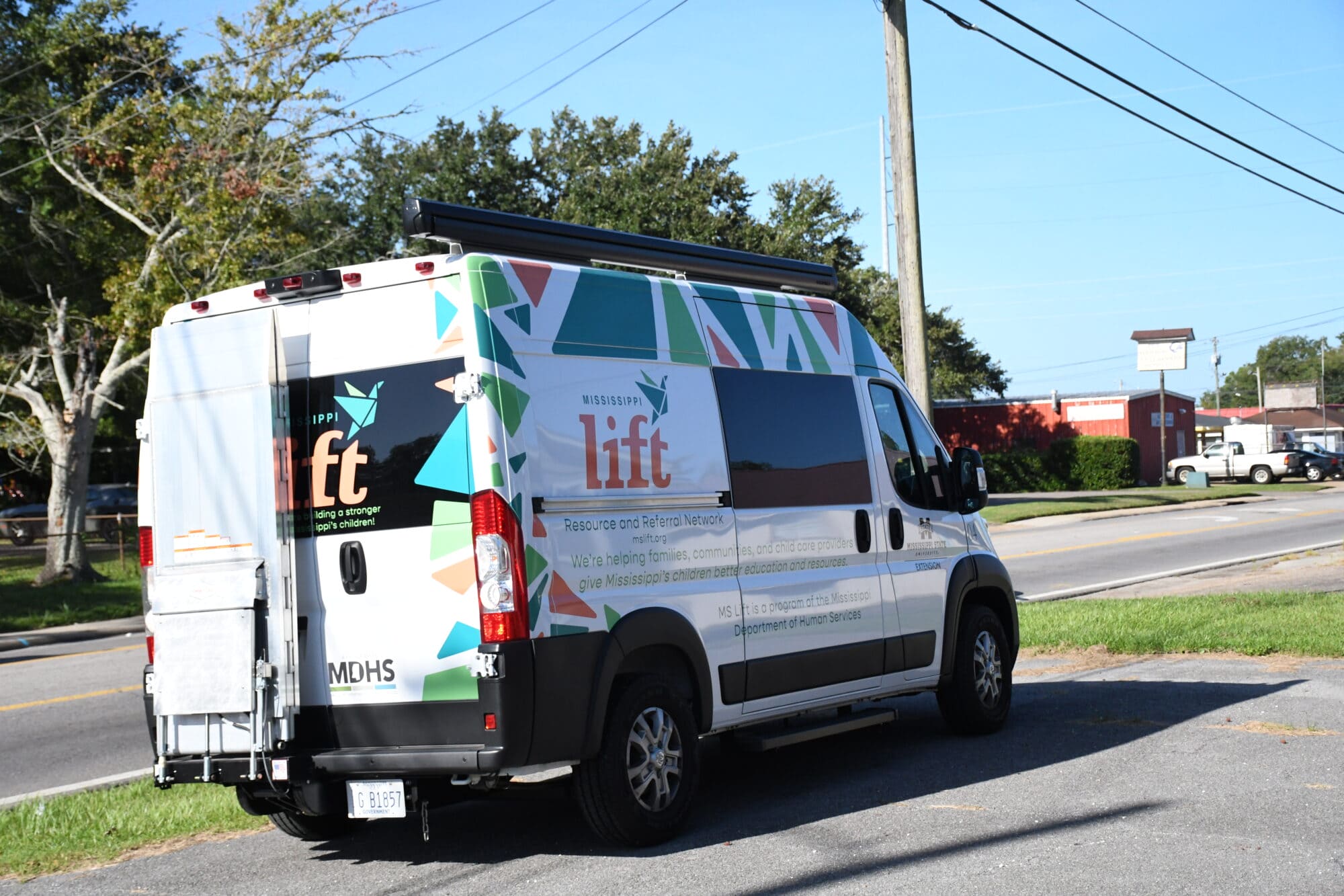 A white MS LIFT Resource and Referral van with colorful graphics is parked outside the organization’s Pascagoula building.